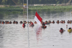 Aquatic anniversary: Environmental activists hold a flag hoisting ceremony in Muara 7 Lake in Pamulang, South Tangerang on Monday to mark the country's Independence Day and promote the preservation of lakes across the country. JP/Dhoni Setiawan