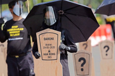 Activists from the Indonesian Migrant Workers Union (SBMI) and Greenpeace Indonesia line up a series of mock-up grave markers in front of the State Palace in Jakarta on Aug. 27. They demanded the government pass a regulation on the protection of Indonesian crewmen (ABK) amid an increase in cases of mistreatment and violence against Indonesian crewmen working on foreign fishing vessels. JP/Wendra Ajistyatama