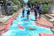 People take selfies by a street mural painted on Jl. Keuangan Raya in Cilandak, Jakarta, on Aug. 25. The mural was painted by sixteen painters from the Jakarta Artists Community. JP/Seto Wardhana