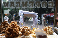 Officers from the Cilandak subdistrict office in South Jakarta carry a fake coffin around the area on Aug. 28 to encourage residents to follow health protocols and stay at home. JP/Dhoni Setiawan