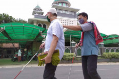 Two blind men walk to the Nurul Ihsan Mosque in Pondok Ranggon, East Jakarta, Friday, Sept. 11, 2020 to perform Friday prayers. The Jakarta administration has reimposed full large-scale social restrictions (PSBB) starting on Sept. 14, 2020. Places of worship in residential areas and housing complexes are allowed to remain open at 50 percent capacity. Larger houses of worship and those located in COVID-19 red zones are required to close. JP/P.J. Leo
