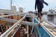 Workers take apart a temporary shelter at Kampung Akuarium, Pejagalan, North Jakarta on Sept. 8, 2020. Residents will be temporarily relocated to low-cost apartments nearby while a kampung susun (elevated village) is built. JP/Seto Wardhana