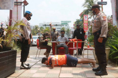 A man is forced to do push-ups by joint security task force personnel on Friday, September 18. 2020 as punishment for his failure to wear a mask. The public punishment was part of a police operation designed to enforce COVID-19 health protocols in Cinere, Depok, West Java. Violators of the protocols are subject to fines or non-judicial punishments such as sweeping the roads, singing national songs or doing push-ups. JP/Dhoni Setiawan