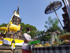 Hindu worshippers sprinkle holy water at Pura Adhitya Jaya before prayers during Galungan celebrations in Rawamangun, East Jakarta, on Wednesday, September 16. 2020. The holiday marks the time when ancestral spirits visit the Earth to see their descendants. JP/P.J. Leo