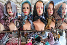 A woman browses through clothing at a stall at the Tanah Abang Market, Central Jakarta, on Sunday, September 13. 2020. Jakarta has gone back to full large-scale social restrictions for two weeks, from Sept. 14 to 25. JP/Seto Wardhana