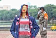 A Jakarta Public Order Agency official stands guard near a mannequin reminding people about the danger of COVID-19 in Sunter, North Jakarta, on Tuesday, September 15. 2020. JP/Seto Wardhana