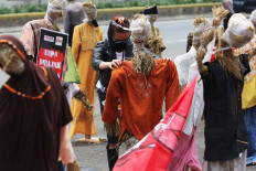 A protester sets up scarecrows during a protest against the omnibus bill on job creation in front of the legislative complex in Jakarta on Sept. 24, which coincides with National Farmers Day. The protesters voiced their opposition to the domestic food supply provisions in the omnibus bill, arguing that it could weaken domestic farmers&rsquo; production and favor importers. JP/Wendra Ajistyatama