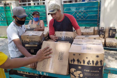Residents distribute staple food to their neighbors in Tengah subdistrict, Kramat Jati, East Jakarta on Sept. 25. The Jakarta administration is distributing grocery packages to low-income families as the administration reinstates the large-scale social restrictions (PSBB). JP/PJ Leo