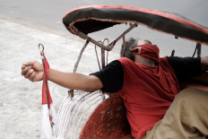 A becak (pedicab) driver naps while wearing a mask in the Malioboro area, Yogyakarta, on October.1. 2020. As of Oct. 4, the province recorded 2,791 COVID-19 cases, with 75 deaths and 2,046 recoveries. JP/Donny Fernando