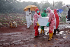 Workers carry the coffin of a COVID-19 victim amid heavy rain at Pondok Ranggon public cemetery in East Jakarta on October. 2. 2020. The Jakarta administration has begun the two-month project of expanding the burial area for COVID-19 patients. In the first phase of expansion, the administration cleared 7,141 square meters. JP/PJ Leo