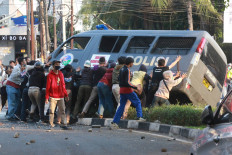 Tipping point: Student protesters overturn a police van during a protest on Wednesday, October 7. 2020 in Pejompongan, Central Jakarta. Demonstrations have taken place in major cities across the country from Tuesday to Thursday to protest the omnibus bill on job creation, which was passed on Monday. JP/Dhoni Setiawan