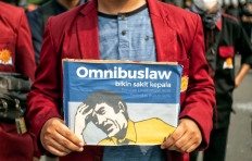 Severe migraine: A student protester holds up a poster based on the packaging design of a headache medicine on Thursday, October 8. 2020 during a demonstration on Jl. M.H. Thamrin in Central Jakarta. The poster reads: &ldquo;The omnibus law causes headaches, environmental damage, workers&rsquo; oppression.&rdquo; JP/Seto Wardhana