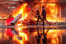 A fire rages at the Hotel Indonesia traffic circle Transjakarta bus shelter on Jl. MH Thamrin, Central Jakarta, during a clash between protesters and the police on Oct. 8. Thousands of workers and students held a rally to reject the Job Creation Law. JP/Seto Wardhana