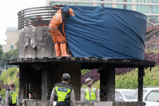 An officer from the city&rsquo;s Public Facility Maintenance Agency (PSSU) covers the upper part of a burned police station in the Tugu Tani area of Central Jakarta, on Oct. 9. Some public facilities were damaged as the result of clashes between the police and protesters during a rally against the Job Creation Law in Jakarta. JP/Dhoni Setiawan