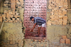 Minan, a brick maker from South Cikarang district in Bekasi, West Java, arranges bricks to be baked in a furnace on Oct. 23. JP/P.J.Leo