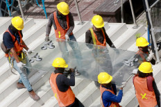 Workers carefully carry a glass plate at Jakarta&rsquo;s oldest high-rise building, Sarinah, on Oct. 30. The iconic shopping center is undergoing a major renovation, costing Rp 700 billion (US$47.9 million). The project is expected to be completed on Aug. 17, 2021, coinciding with Sarinah&rsquo;s 59th anniversary. JP/Dhoni Setiawan