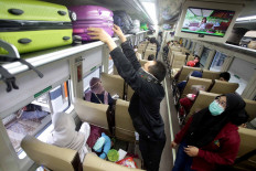 A passenger arranges his luggage on the Kertajaya train, serving the Jakarta&ndash;Surabaya route, at Senen Station in Jakarta on Oct. 27. Many people chose to travel during their extended holiday despite the risk of contracting the coronavirus. JP/Wendra Ajistyatama