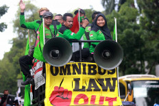Members of labor unions take to the streets on a vehicle at Jl. Medan Merdeka Selatan near the Presidential Palace in Jakarta on Nov. 2, 2020. They were protesting against the controversial Job Creation Law and demanded an increase to the minimum wage in 2021. JP/Dhoni Setiawan