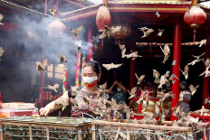 A Confucian follower releases sparrows at the Kim Tek Ie Temple in Glodok, West Jakarta, on Nov. 4, 2020. Devotees offer prayers and release sparrows to commemorate the birthday of Kwan Im, the Chinese goddess of mercy, which falls on the 19th day of the ninth month of the Chinese calendar. JP/P.J. Leo