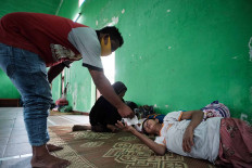 A man distributes face masks to villagers taking refuge from the possible eruption of Mount Merapi, at Balerante village hall in Klaten, Central Java, on Monday, Nov 9. JP/Donny Fernando