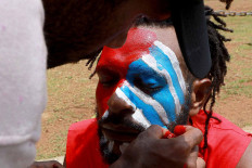 A Papuan Student Alliance (AMP) member has his face painted with the colors of the Bintang Kejora (Morning Star) flag during a protest on Jl. Medan Merdeka Barat, Central Jakarta, on Nov. 16. The protesters demanded that the government thoroughly investigate the killing of Papuan pastor Yeremia Zanambani in Intan Jaya, Papua, and withdraw military and police personnel from the country&rsquo;s easternmost province. JP/Dhoni Setiawan