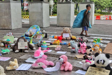 A boy with a bag of scavenged goods looks at toys displayed to commemorate World Children&rsquo;s Day in Jakarta on Nov. 20. The Extinction Rebellion (XR) group displayed hundreds of toys to represent Indonesian children and urged the government to do more to protect them. JP/Seto Wardhana