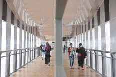 People walk across a new pedestrian bridge in Senen, Central Jakarta, on Nov. 22. The footbridge, which also provides access to a Transjakarta bus shelter, is still under trial and will soon be open to the public. JP/Wendra Ajistyatama