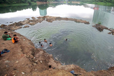 Children play in the Ria Rio reservoir in East Jakarta on Nov. 24. The Jakarta Water Resources Agency hopes to dredge five reservoirs and 13 rivers by December to mitigate flooding in the capital. JP/Wendra Ajistyatama