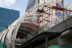 Workers install the roof of an LRT station on Jl. Rasuna Said in South Jakarta on Dec. 2. The Jakarta administration has announced its intention to change the planned route of the LRT line to run from Pegangsaan 2 via Velodrome to Klender instead of to Dukuh Atas, as previously planned. JP/P.J.Leo
