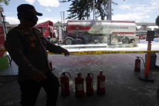 A police officer guards a Pertamina fuel station on Jl. MT Haryono in South Jakarta after a fuel tanker had caught fire on Dec. 1. Fuel station workers managed to put out the flames. JP/Wendra Ajistyatama