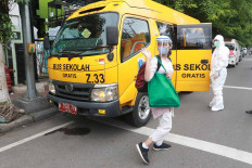 Health workers transport patients by school bus to the emergency COVID-19 hospital in Kemayoran, Central Jakarta, from the Kebayoran Lama community health center in South Jakarta on Nov. 30. JP/Dhoni Setiawan
