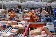 Employees sort out goods at a Lazada warehouse in Cimanggis, West Java, on Dec. 17. During Lazada&rsquo;s three-day national online shopping (Garbolnas) held on Dec. 12-14, the online shop saw a 100 percent increase in sales compared with 2019. Bank Indonesia (BI) recorded Rp 180.74 trillion (US$ 12.8 billion) in e-commerce transactions as of September, lower than the 2019 figure of Rp 201 trillion. JP/Seto Wardhana