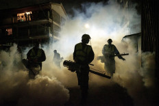 Volunteers from Sonko Rescue Team, an NGO privately funded by Nairobi Governor Mike Sonko, fumigate a street to curb the spread of COVID-19 during a joint operation with Nairobi county during a 7pm-5am curfew at a residential area in Nairobi, Kenya, on April 6, 2020. - Kenyan President Uhuru Kenyatta on April 6 imposed a three-week ban on movement in and out of four main coronavirus "infected areas", including the capital Nairobi, ahead of the usually busy Easter weekend. Kenya currently counts 158 cases and six deaths from the virus, most of them in the capital, with a few cases also along the coast. AFP/Yasuyoshi Chiba