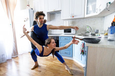 Bolshoi theatre leading soloist Igor Tsvirko and first soloist Margarita Shrainer attend a lesson in the kitchen of their apartment in Moscow on April 29, 2020 during a strict lockdown in Russia to stop the spread of the COVID-19 infection caused by the novel coronavirus. - In the middle of their bedroom, Bolshoi ballet dancers Margarita Shrainer and Igor Tsvirko have placed a linoleum mat and a barre. Since the start of the lockdown, the couple, both soloists in the legendary troupe, have largely used their own initiative to keep up their dance skills at home. AFP/Kirill Kudryavtsev 