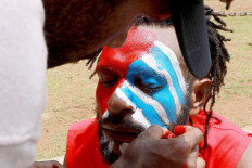 Justice seekers: A Papuan Students Alliance (AMP) member has his face painted with the colors of the Bintang Kejora (Morning Star) flag during a protest on Jl Medan Merdeka Barat, Central Jakarta on Nov. 16. The protesters demanded that the government thoroughly investigate the killing of Papuan pastor Yeremia Zanambani in Intan Jaya, Papua, and withdraw military and police personnel from the country&rsquo;s easternmost province. JP/ Dhoni Setiawan