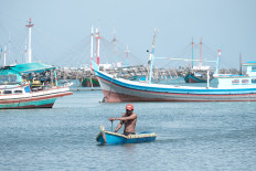 Way back home: After overcoming turbulent waves in the wake of larger ships, we, just like the fisherman here in his dinghy, head home to our lands. (Courtesy of Donny Fernando/-)