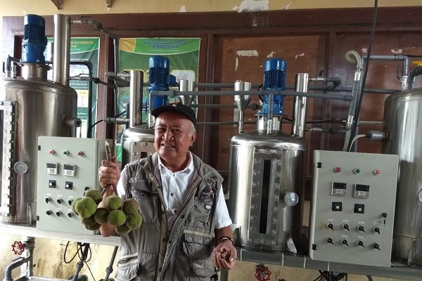 Biofuel researcher Dibyo Pranowo stands in front of the prototype of a biodiesel reactor he invented as he shows drupes (left) and kernels of &lsquo;kemiri sunan&rsquo; (Sunan candlenut) on Jan. 16, 2019, at the Agriculture Ministry&rsquo;s research center in Sukabumi, West Java.
