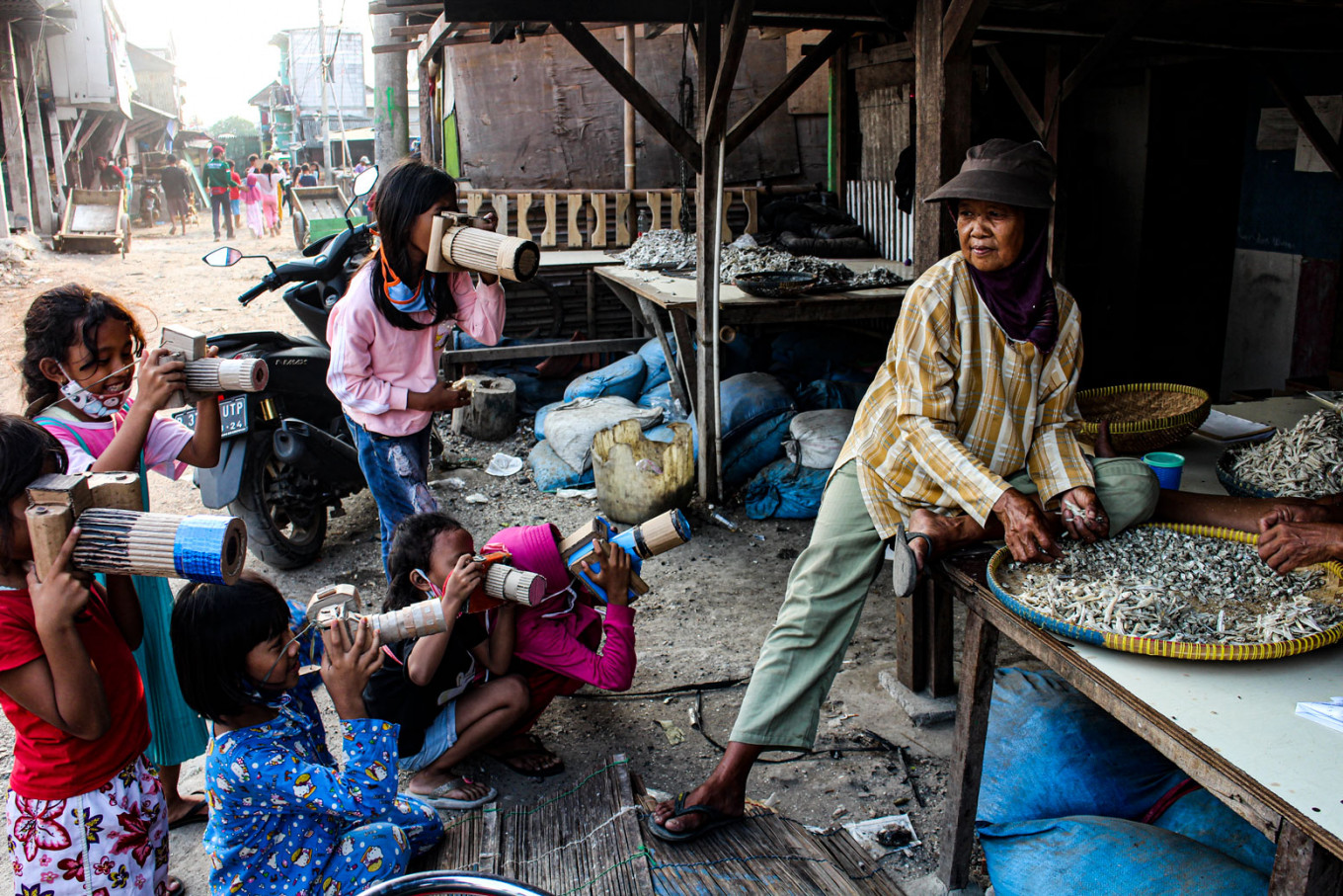 Children take photos of a local woman in their village by using homemade cardboard cameras.