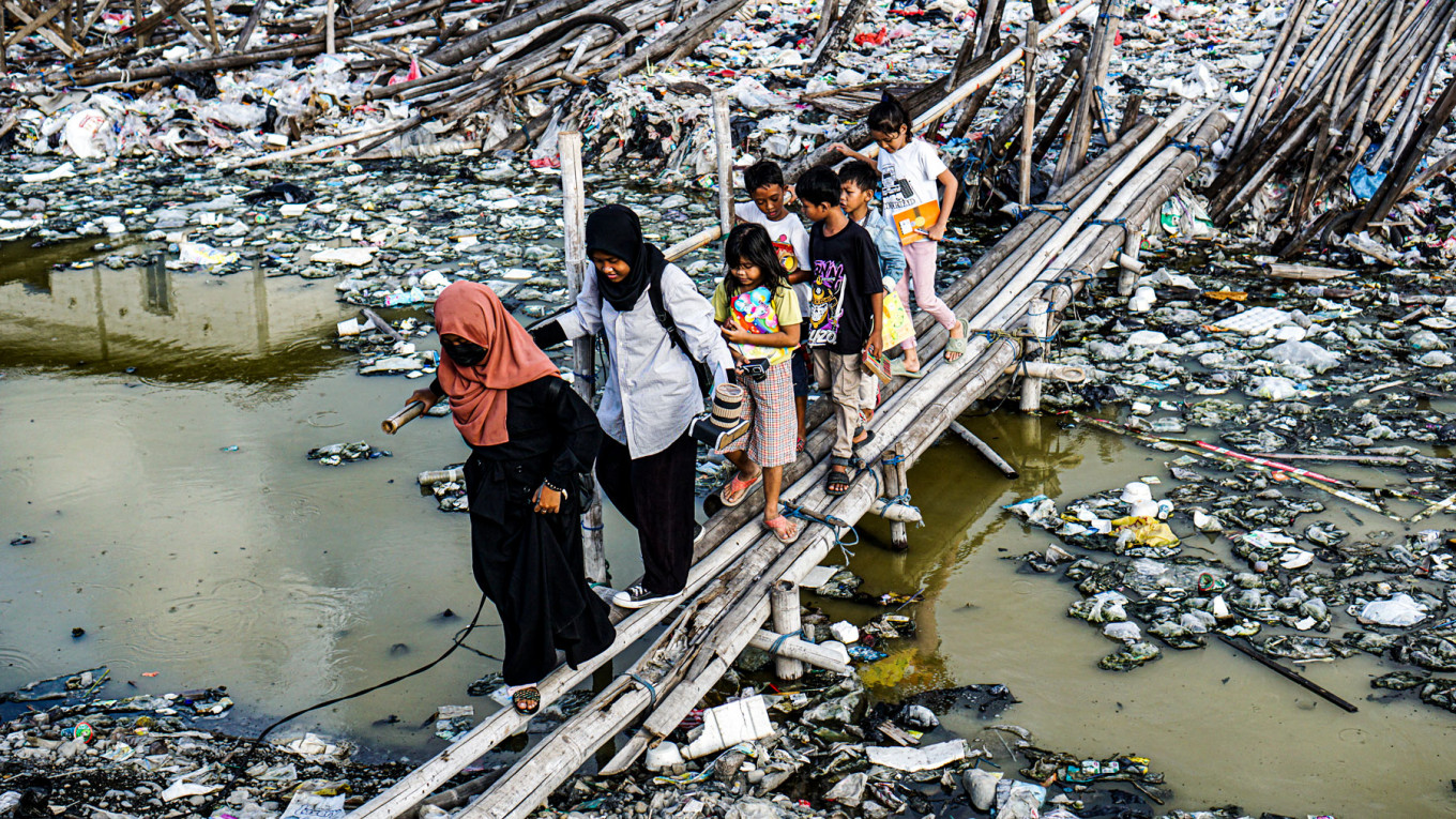 Children enthusiastically walk across a bamboo bridge to learn new things in Kelas Jurnalis Cilik.