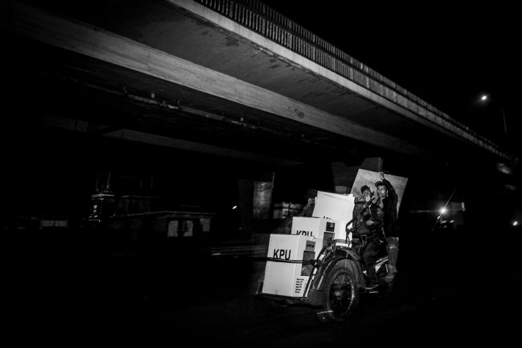 Hansip (local civil defense) personnel deliver ballot papers to the Kawasan 9/10 Ulu subdistrict office on April 17, 2019, in Palembang, South Sumatra, after the vote counting process finished on election day.